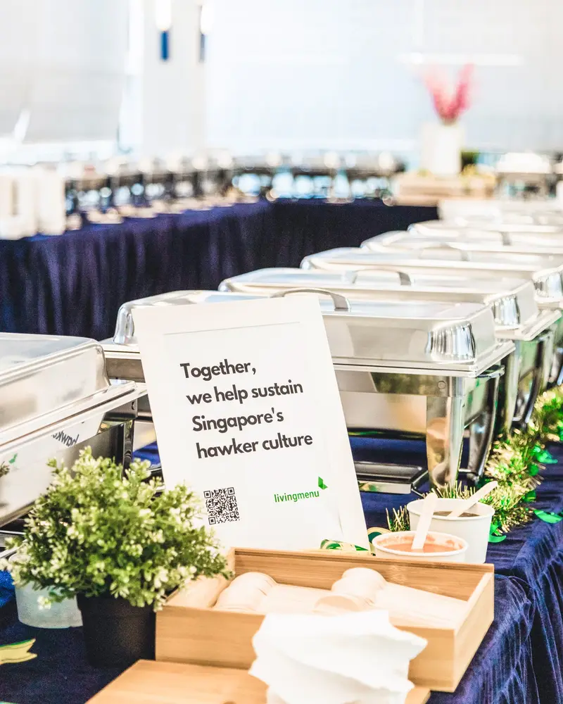 Hawker buffet catering setup with a sign reading: Together, we help sustain Singapore's hawker culture