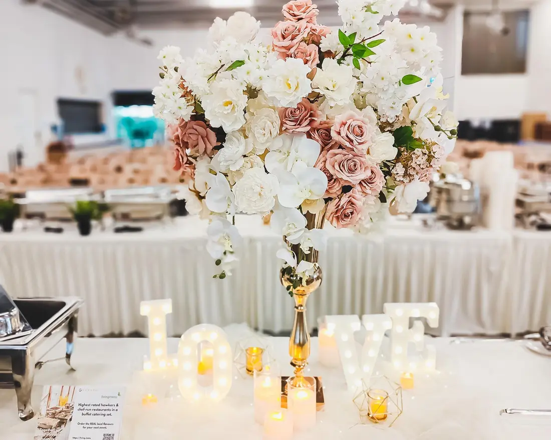 Wedding buffet catering setup with floral centrepiece and food warmers in Singapore