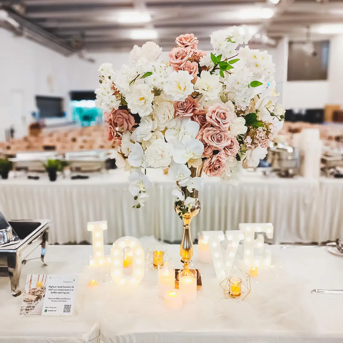 Wedding buffet catering setup with floral centrepiece and food warmers in Singapore